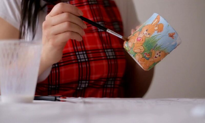 devojka pravi dekupaž šolju